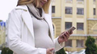 Büyük şehirde, o polis eşliğindeki gezinmek için mobil app kullanarak oldukça hamile kadın