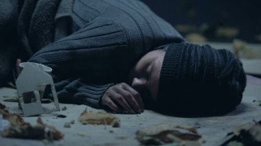 Paralar Kupası kağıt ev, sokakta uyuyan evsiz vagabond koyarak adam