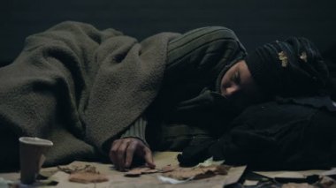 Depresif mülteci soğuk ile titreyerek Kağıt aile resimler, anılar seyir