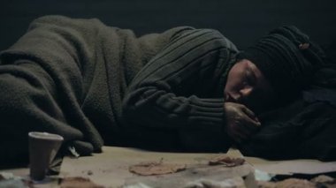 Evsiz kişi yerde yatarken ve öksürük, hastalık tüberküloz acı
