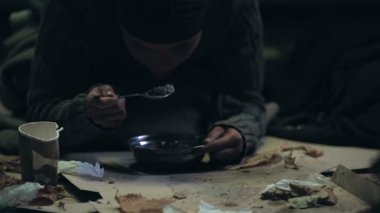 Aç serseri iştahla yemek çorba, passer koyarak Dilenci Kupası, sadaka madeni paralar