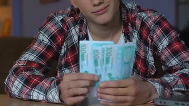 豊富な若い男カウント ユーロ紙幣 投資計画の家のテーブルに座って — ストック動画