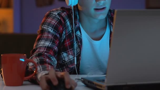 神経行動でオンライン ゲームをプレーのヘッドセットではまっている男性のティーンエイ ジャー — ストック動画