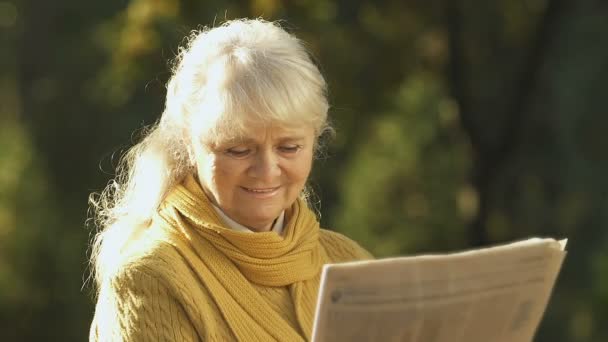 Stará Žena Čte Dobrou Zprávu Novinách Penzijní Reformě Odpočívá Parku — Stock video