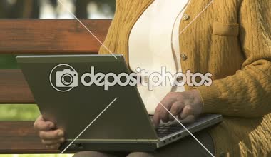 Gülümseyen yavaş yavaş laptop yazarak, dışarıda dinlenme, internet tarama Bayan emekli