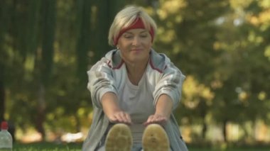 Kızı ve yaşlı anne eğitim birlikte çimenlerin üzerinde uzanan bacaklar oturan