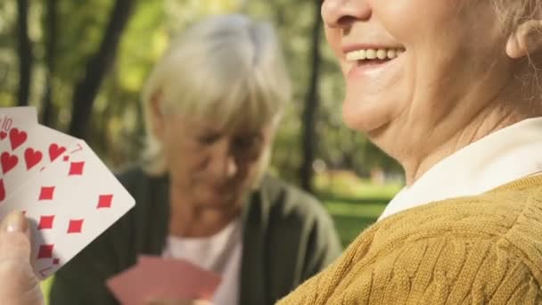 Leende Senior Kvinna Spelkort Med Vän Utanför Pensionering Fritid — Stockvideo