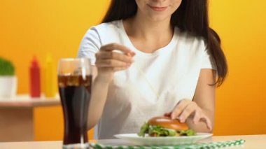 Genç kadın lezzetli hamburger fast food Restoran, sağlıksız yemek yeme