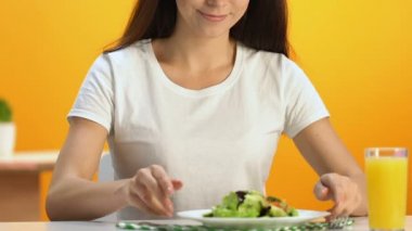 Şirin esmer taze vitaminized salata ve gülümseyerek, diyet ile plaka tutarak