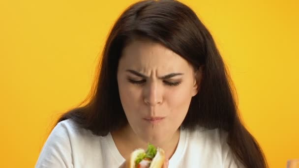 褐发女郎女孩品尝热狗 震惊的恶心的味道和劣质餐 — 图库视频影像