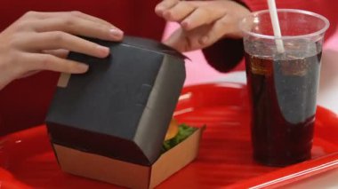 Eller sağlıksız sandviç tatma lokanta burger ile kutusunu açma