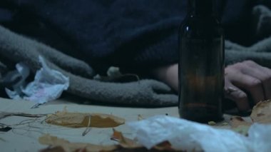 Yaralar yandan acı alkol ile sarhoş sarhoş dilenci çöp içinde yalan