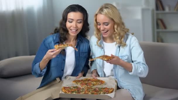 两个饥饿的女学生享受巨大美味的比萨饼室内 食品交付 — 图库视频影像