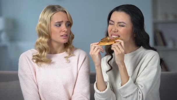 Vrouw Eet Smakelijk Pizza Terwijl Vriend Vechten Met Fast Food — Stockvideo