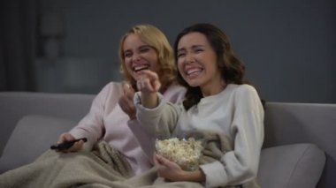 İki genç güzel kadın komedi izlemek ve yüksek sesle gülme, komik film