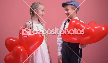 Sevimli küçük çift elele ve gülümseyen, balonlu çocuklar aşk randevu
