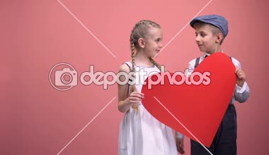 Büyük kırmızı kalp sarılma ve gülümseyen, Romantik Sevgililer günü ile genç çift