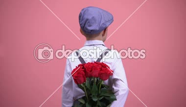 Gül sırt ve kamera için dönüm arkasında saklanıyor küçük beyefendi çocuk gülümseyen