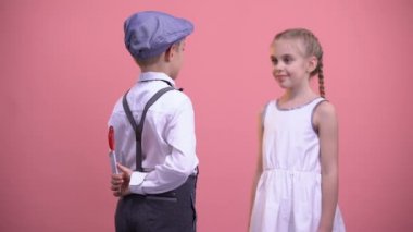 Kırmızı kalpli lolipop kız, tatlı romantik hediye veren küçük çocuk