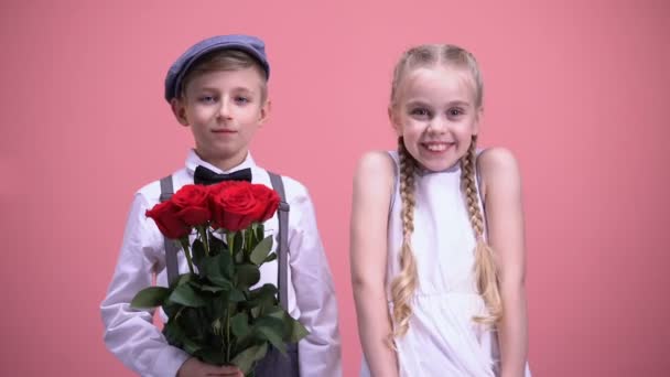 Uśmiechnięte Dziewczyny Chłopaka Trochę Gospodarstwa Czerwone Kwiaty Patrząc Kamery — Wideo stockowe