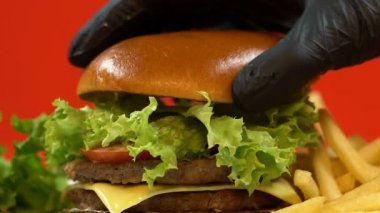Kişi elinde eldiven lezzetli hamburger, temizlik mutfak, closeup hazırlanıyor