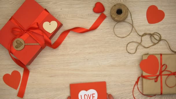 Hände Mit Valentinstag Grußkarte Mit Liebeswort Geschenkschachteln Auf Hintergrund — Stockvideo