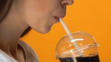 Susuz kız ile saman, plastik bardak soğuk gazlı içecek içme yakın çekim