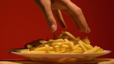 Kadının alarak patates kızartması el plaka, abur cubur bağımlılığı, ağır çekim