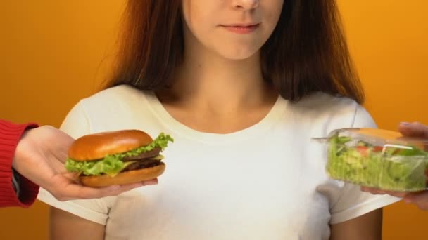 ハンバーガー 健康的な食事の概念の代わりにグリーン サラダを選択する笑顔の女性 — ストック動画