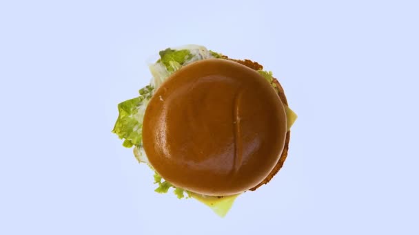 白い背景 不健康なジャンク フード 上面の回転脂肪ハンバーガー — ストック動画