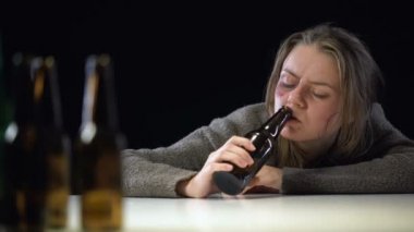 Akşamdan kalma, umutsuzluk acı masanın üzerinde yatan ve bira içme kadın bağımlısı