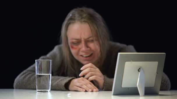 depressive weinende Dame beim Anblick von Fotos mit Antidepressiva, Gewaltopfer