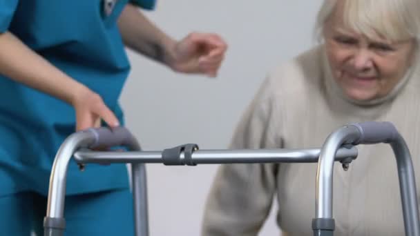 Nurse Helping Aging Lady Suffering Arthritis Stand Take Walking Frame — Stock Video