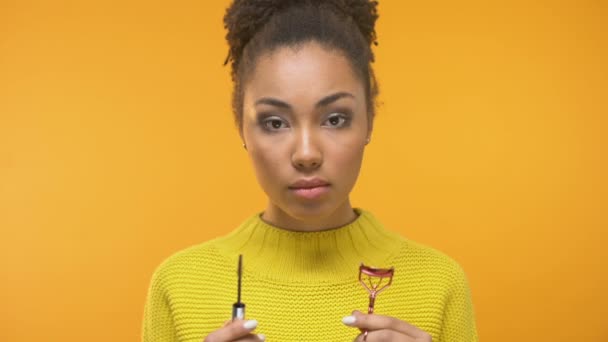 Mujer Negra Confusa Mirando Rímel Rizador Pestañas Necesita Consejos Maquillaje — Vídeo de stock