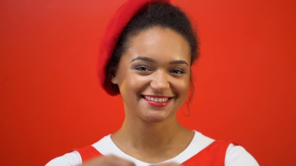 優しさ 慈善活動 赤い背景の中心を作る笑顔の女性 — ストック動画