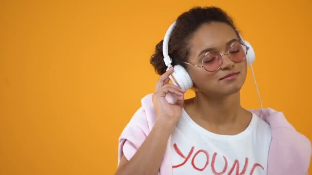 ヘッドフォン ラジオ アプリケーションでお気に入りの音楽を楽しむスタイリッシュな女性 — ストック動画