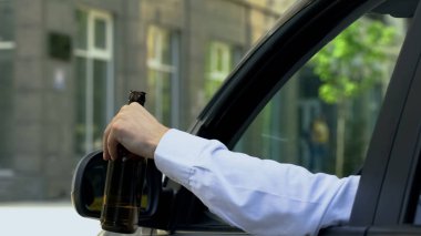 Man holding beer bottle inside car, drinking alcohol while driving, crash risk clipart