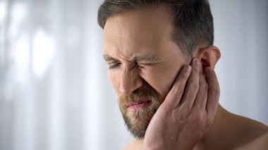 Ağrıyan kulağı tutan adam acı otitis, ani işitme kaybı, yakın çekim