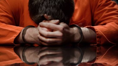 Inmate holds his head in desperate, feels regret about committing crime, closeup clipart