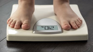 Vücut ağırlığı, kilolu sorun, closeup denetlemek için ölçekler üzerinde duran obez kadın