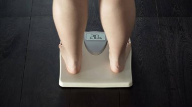 Ekstra kilo sorunu, kilolu kadın ayakta ölçekler, obezite, arka görüş