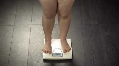 Tombul kadın ayakta ev ölçekler, normal kilolu, başarılı diyet sonuç