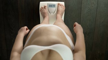 Kilolu kadın üstten görünüm ölçeklerde ekranında, sağlık sorunu, kelime diyet ile