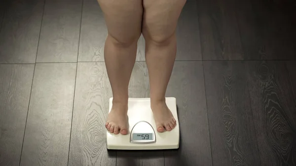 胖乎乎的女性站在秤上 检查饮食后的体重 身体控制 — 图库照片