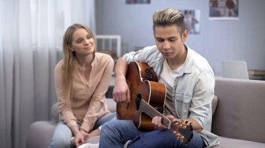 Gitar çalmak onun kalbini, romantizm fetih kız arkadaşına aşık genç çocuk