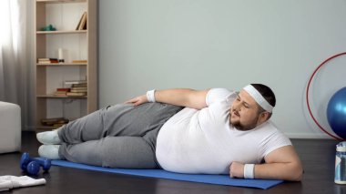 Mat yalan, fiziksel egzersizleri evde yapıyor büyük boy adam ağırlık yanan