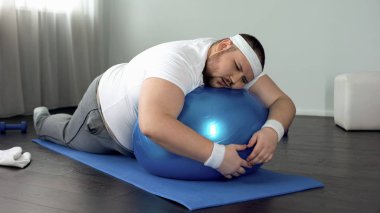 Şişman adam fitness topu, evde egzersiz molası, tembellik rahatlatıcı zayıf iradeli