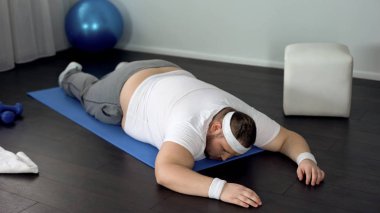 Mindere, eğitim sırasında yorgun kasları pes yatan hiç motivasyonu olmayan adam
