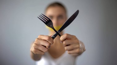 Woman crossing fork and knife, mouth closed with tape, self-restriction in food clipart