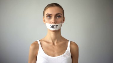 Diet word written on taped mouth of anorexic model, severe diet, health problems clipart